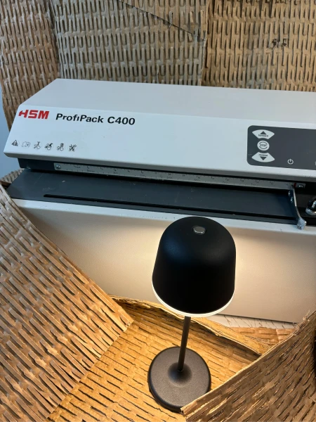 Rozsvícená lampička v krabici s kartonovou výplní, v pozadí skartovačka ProfiPack C400